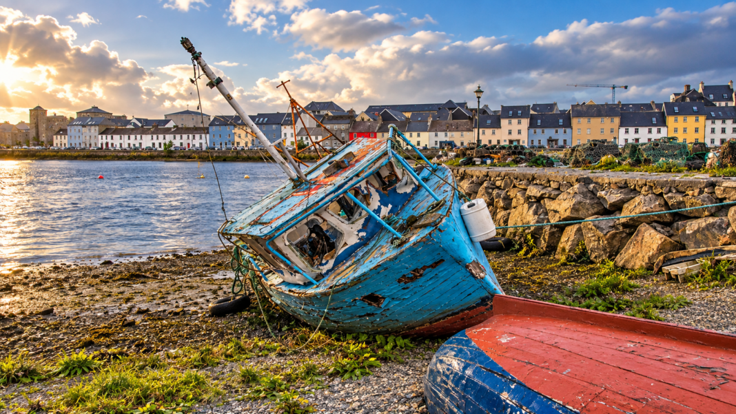 Weathered fishing boats at Nimmo’s Pier with Galway waterfront buildings behind