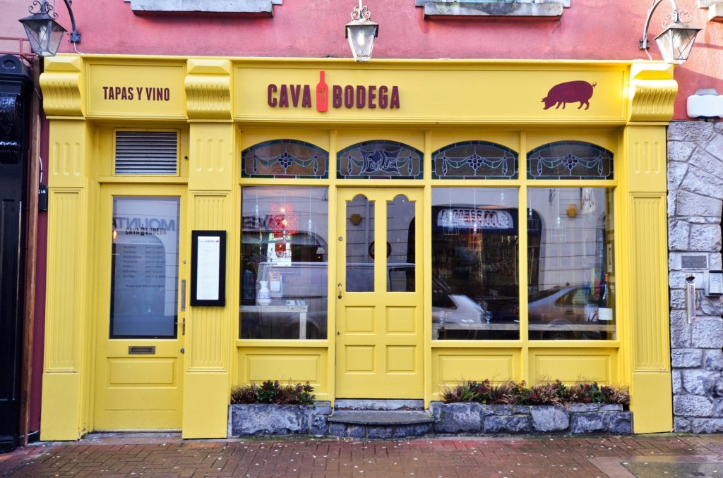Yellow Cava Bodega entrance with Tapas y Vino signage on Middle Street
