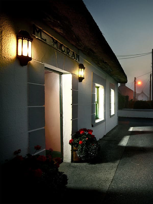 Moran’s Oyster Cottage: A Seafood Stop at The Weir, Kilcolgan Thatched Moran's Oyster Cottage exterior with illuminated windows and entrance at The Weir