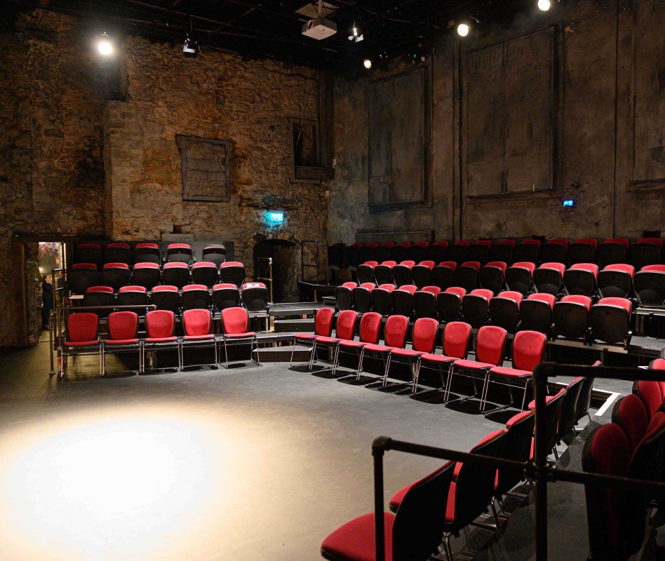 The Mick Lally Theatre Galway: An Evening at Druid’s Home Red seats around the stage inside the stone-walled Mick Lally Theatre in Galway
