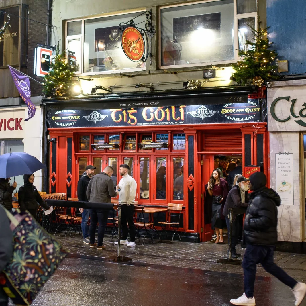 Illuminated red facade of Tig Choili traditional music pub in Galway